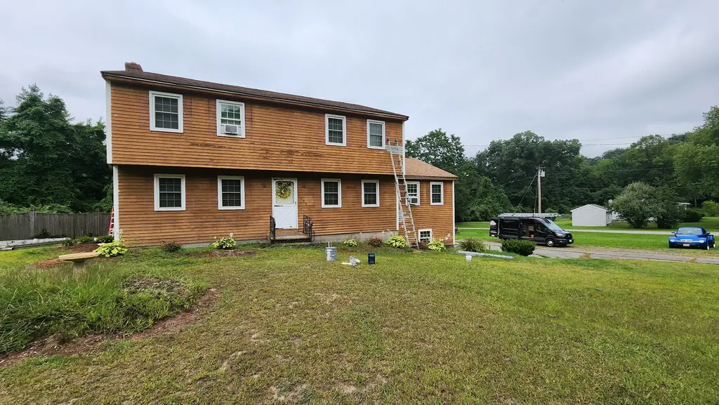 Cedar clapboard colonial with an aluminium ladder set against the facade